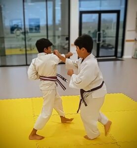 Two young karate students practice defending an attack